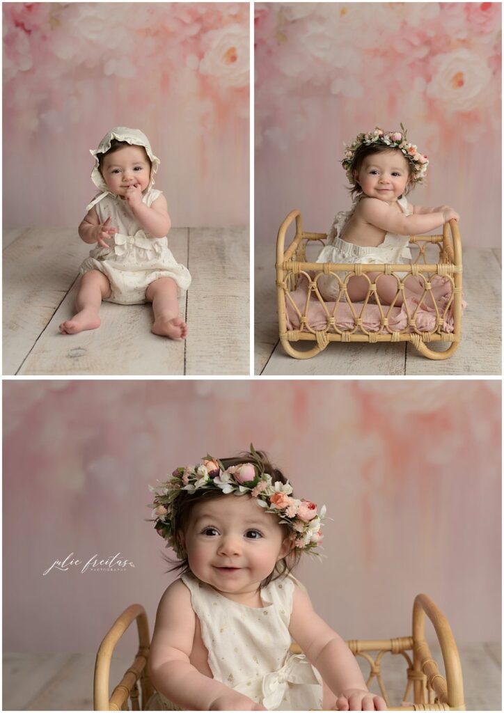 six month old baby wearing a white romper with a pink floral background